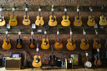 Many guitars hung on the wall of Emerald City Guitars