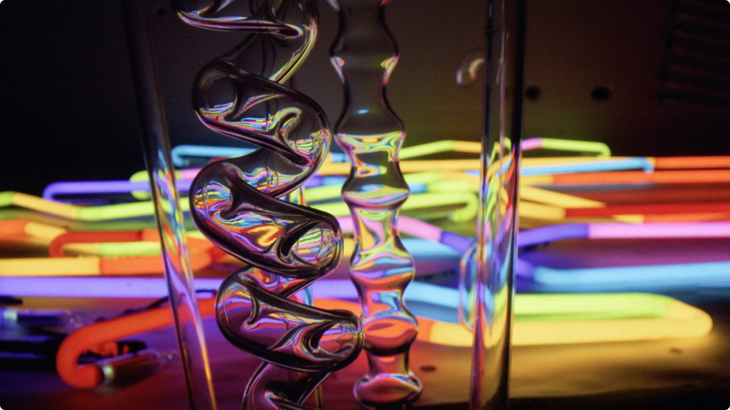 Glass tubes and neon lit up in a dark room.